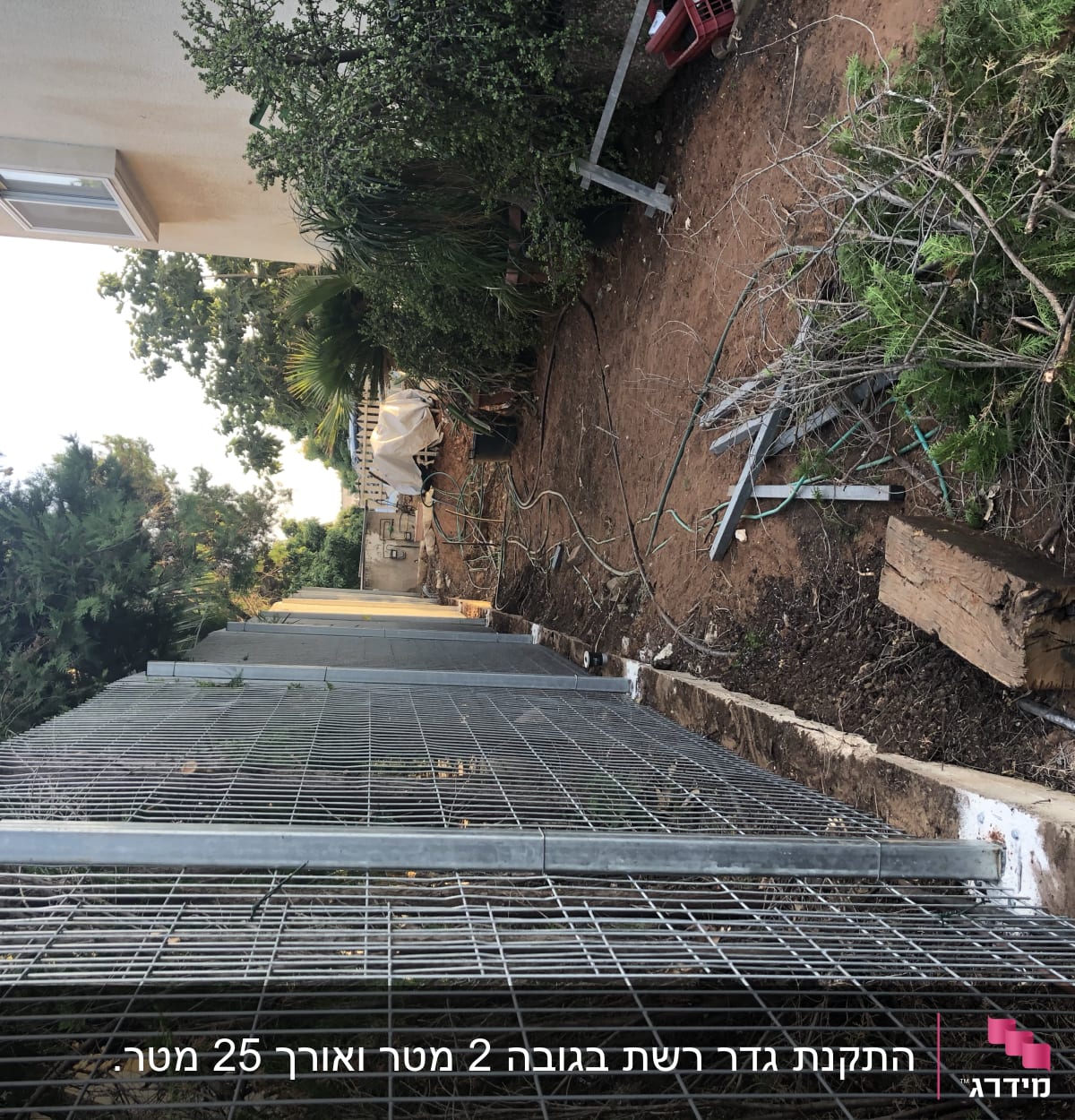 מסגרת מתכתית גדולה מונחת על הקרקע ליד שיחים